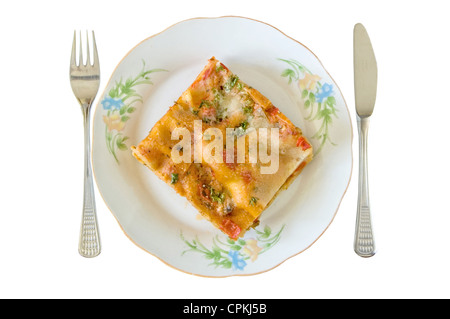 Lasagne-Slice in einem Teller mit Gabel und Messer isoliert auf weiss Stockfoto