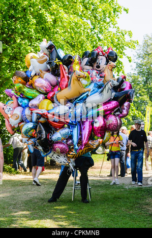 Mann, der große Anzahl von Helium-Ballons Stockfoto