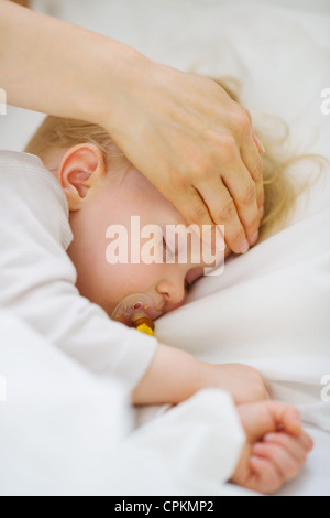 Closeup auf Überprüfung der Temperatur der Stirn des Baby Mutter Stockfoto