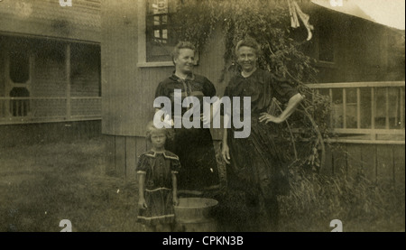 August 1905 Foto, Großmutter, Frau und Enkelin Aufhängen von Wäsche im Haus in Plymouth, Massachusetts, USA. Stockfoto