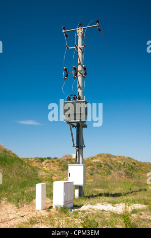 elektrische Pylon mit Isolatoren auf blauen Himmelshintergrund Stockfoto