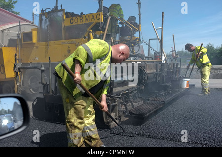 Männer legen Asphalt auf einer Straße in Penryn, Cornwall Stockfoto