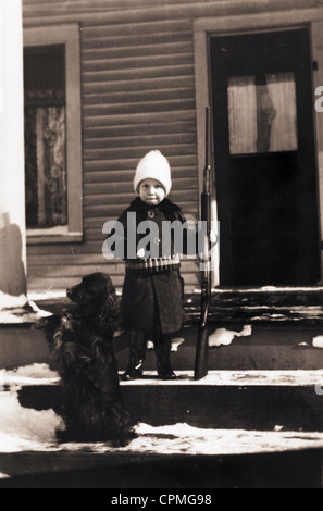 Schwer bewaffnet, Little Boy & Hund Wache Homestead Stockfoto