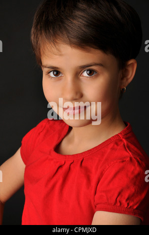 Altklug lächelnd Adolescent Bi-Rasse weiblich mit Pixie Haarschnitt trägt ein rotes t-shirt Stockfoto