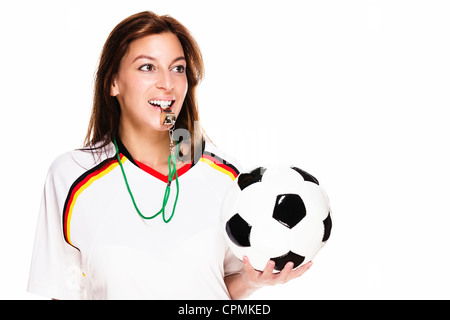 schöne Frau mit Fußballtrikot mit einer Pfeife hält Fußball auf weißem Hintergrund Stockfoto