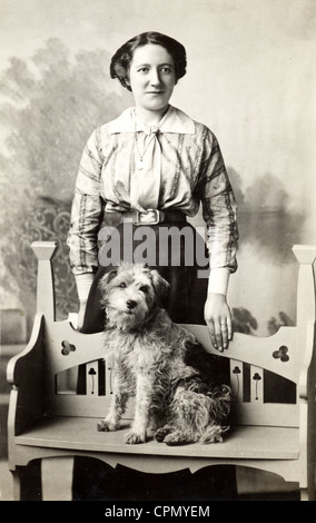 Applying Frau mit Terrier auf Handwerker-Bank sitzen Stockfoto