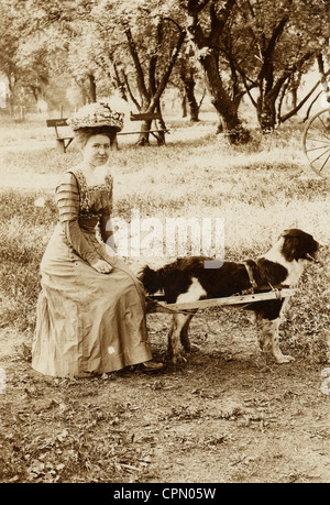 Schüchternes Mädchen in Hund gezogenen Wagen sitzt gut gekleidet Stockfoto