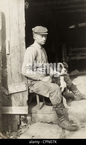 Handwerker in Tür mit seinem Hund sitzend Stockfoto