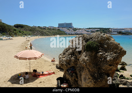 Eine junge Familie unter einer Sonne Brolly arenal d ' en Castell Menorca Balearen Inseln Spanien Stockfoto