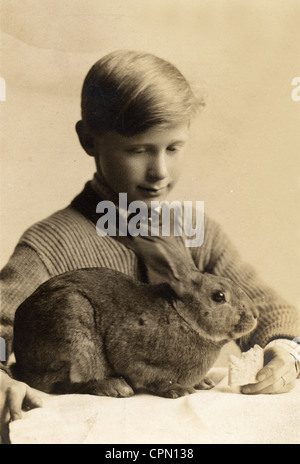 Kleiner Junge Fütterung sein Haustier Kaninchen einen Cracker Stockfoto