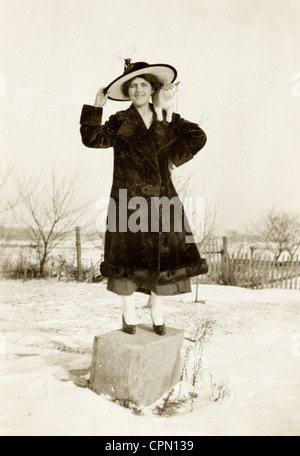 Frau Perched auf konkrete Marker mit einer Katze auf der Schulter Stockfoto