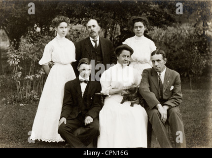 Wohlhabenden Familie von sechs mit Katzenmutter Holding Stockfoto