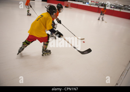 Zehn Jahre alten Hockeyspieler in Eisbahn schlagen ein Puck, Jugend-Hockey-League-Spiel. Stockfoto