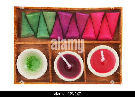 Räucherstäbchen und Duftkerzen in einem Holztablett isoliert gegen weiß Stockfoto