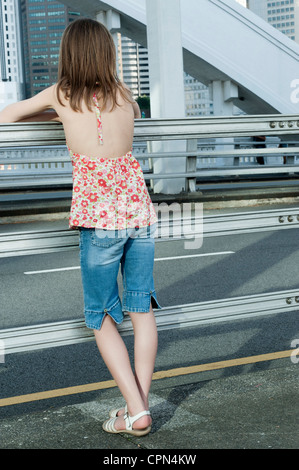 Mädchen gelehnt Geländer auf der Straße Stockfoto
