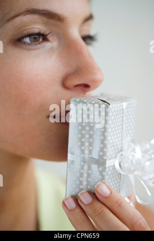 Frau küssen verpackt Geschenk Stockfoto