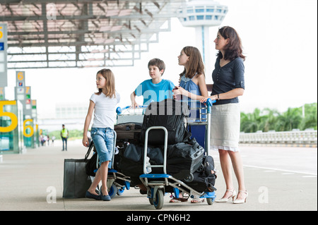 Familie stehen außerhalb der Flughafen mit Gepäck Stockfoto