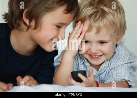 Brüder spielen mit Handy Stockfoto