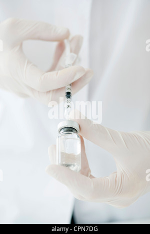 Gewinnung von Flüssigkeit aus Fläschchen mit Spritze Stockfoto