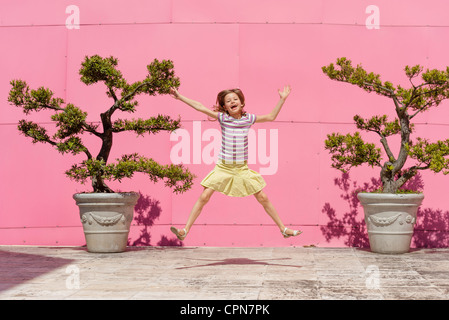 Mädchen springt in die Luft, Porträt Stockfoto