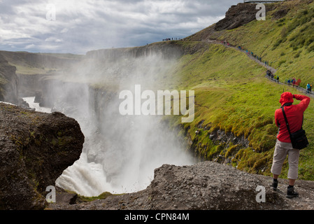 Touristen stehen am Rand der Gullfoss Wasserfall, Island Stockfoto