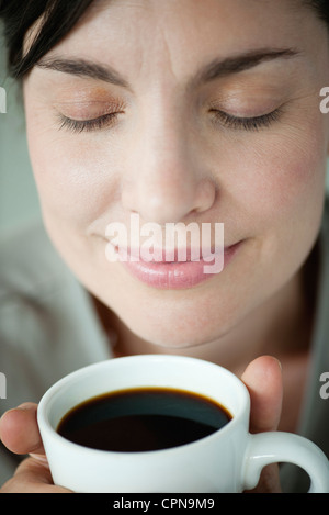 Mid-Adult Woman duftenden Tasse Kaffee Stockfoto