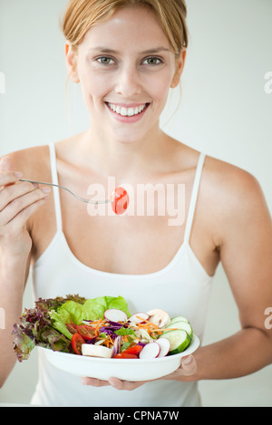 Junge Frau, die Schüssel Salat zu essen Stockfoto
