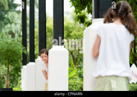 Mädchen spielen verstecken im freien Stockfoto