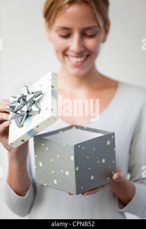 Junge Frau, die Geschenkbox zu öffnen Stockfoto