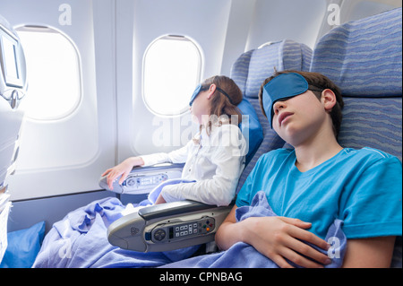 Kinder schlafen im Flugzeug Stockfoto