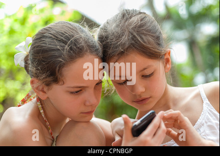 Schwestern betrachten Handy zusammen Stockfoto