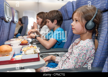 Mädchen Film auf Flugzeug, Fluggesellschaft Mahlzeit auf Tablett-Tisch Stockfoto