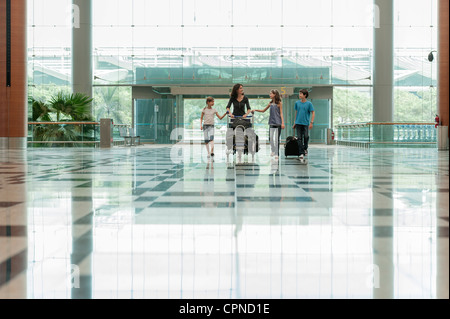 Familie Flughafen Lobby Gepäckwagen einschieben Stockfoto