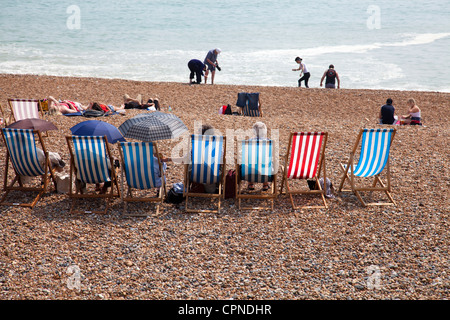 Reihe von Liegestühlen am Strand von Brighton - UK Stockfoto