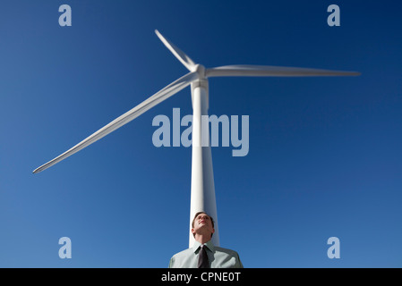 Geschäftsmann, lehnte sich gegen Windkraftanlage Stockfoto