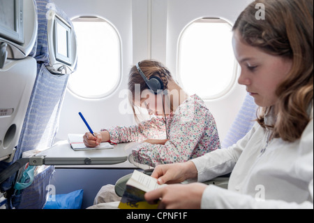 Mädchen auf Flugzeug mit Kopfhörern Musik hören Stockfoto