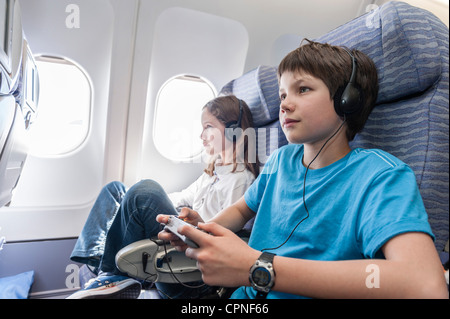 Junge mit Fernbedienung zum Umschalten auf Flugzeug Stockfoto