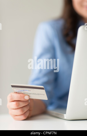 Frau mit Kreditkarte neben Laptop-computer Stockfoto