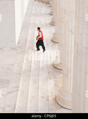 Person, die Treppenstufen neben Spalten Stockfoto