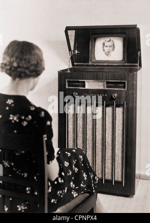 Broadcast,Fernsehen,Fernsehempfänger Telefunken FE VI,Zuschauer beim Fernsehen Bild über Flip offenen Spiegel in der Abdeckung des Fernsehschranks,Bildröhre wird vertikal in Fernsehgerät installiert,Kathodenstrahlröhre mit 35 Zentimeter Durchmesser,konstruiert für 441 Linien Standard,Bild des Produzenten,Berlin,Deutschland,1937,1938,Vorkriegsfernsehen,Standalone-Gerät,Fernsehzuschauer,Frau,Frauen,Spiegelansicht,Fernsehzuschauer,Fernsehzuschauer,Erfindung,Erfindungen,Fernsehempfänger,Fernsehgeschichte,Wertergeschichte,andere-Geschichte,Werterrechte,Wertereife,Werterrechte,Wertereife,Wertereife,Wertereife,Wertereife,Wertereife,Werter Verfügbar Stockfoto
