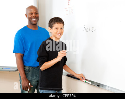 Afrikanische amerikanische Lehrer und Schüler einfache Algebra-Formel an der Tafel zu tun. Stockfoto