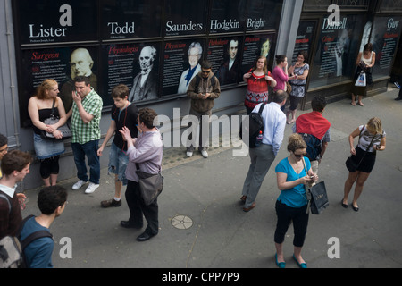 Luftaufnahme der Pendler auf eine Stadtbushaltestelle außerhalb Kings College auf dem Strand, deren Absolventen Gesichter und Namen schmücken die Außenseite des London College. Stockfoto