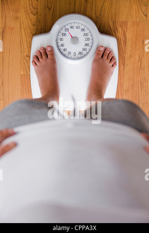 Kaukasische Frau stand im Maßstab Stockfoto