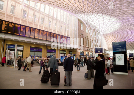 Die Leute, die auf der Suche an der Abfahrt auf die Bahnhofshalle, Kings Cross Station, London UK Stockfoto