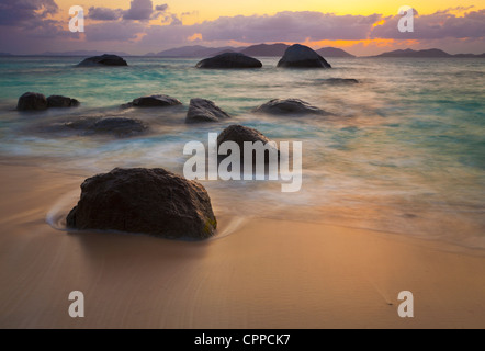 Virgin Gorda, Britische Jungferninseln, Karibik Felsbrocken awash in der Brandung des kleinen Trunk Bay in der Nähe von den Bädern bei Sonnenuntergang Stockfoto