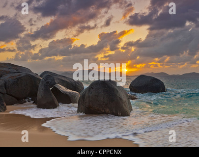 Virgin Gorda, Britische Jungferninseln, Karibik Felsbrocken awash in der Brandung des kleinen Trunk Bay in der Nähe von den Bädern bei Sonnenuntergang Stockfoto