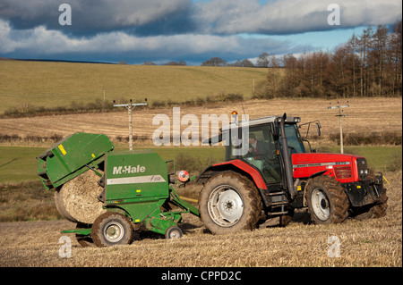 Ballen Stroh mit McHale Ballenpressen und Massey Ferguson Traktor. Stockfoto