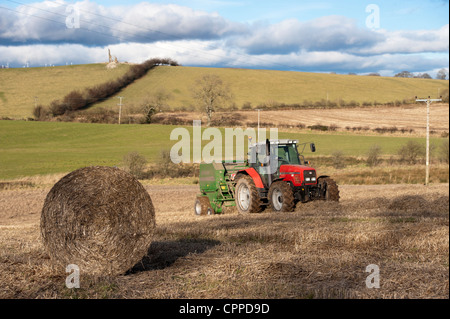 Ballen Stroh mit McHale Ballenpressen und Massey Ferguson Traktor. Stockfoto