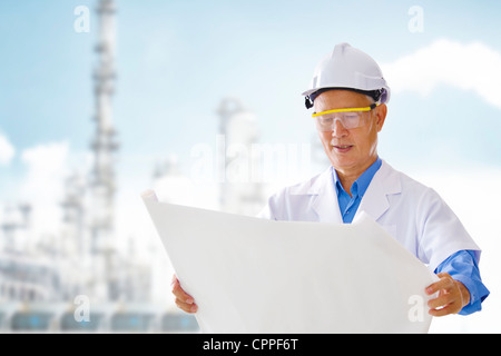 Asiatische Senior Ingenieur mit Blaupausen stehen außen Anlage Stockfoto