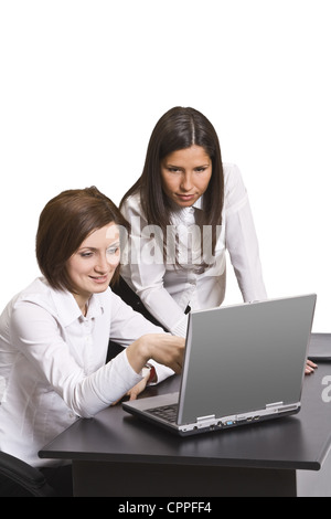 Zwei junge Geschäftsfrau, die gemeinsam auf einem Laptop an ihren Schreibtisch. Stockfoto